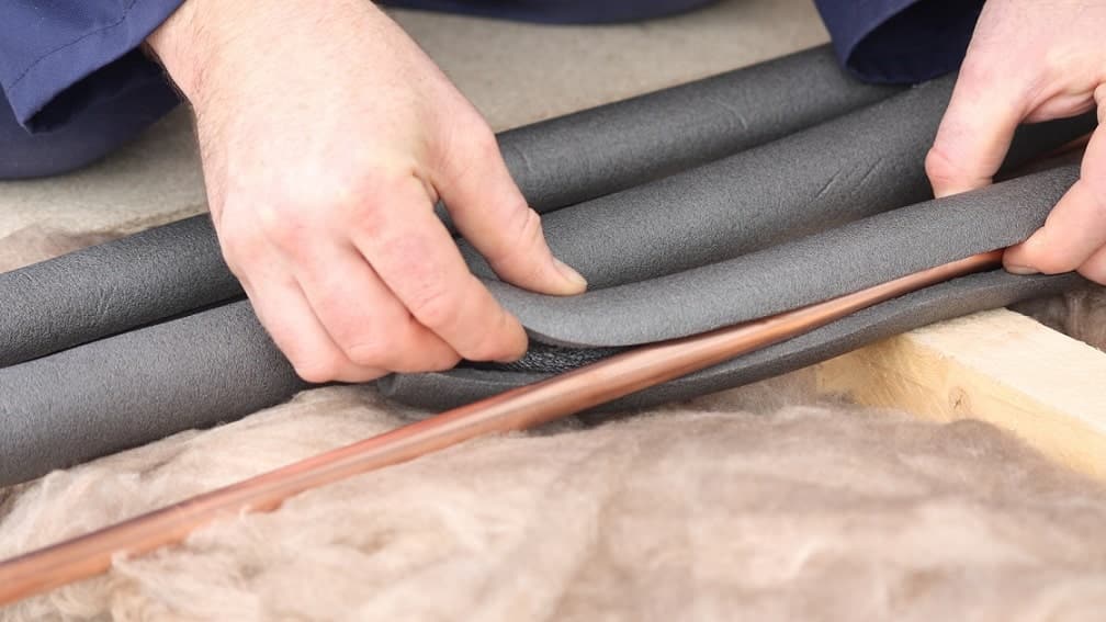 placing insulation around pipe